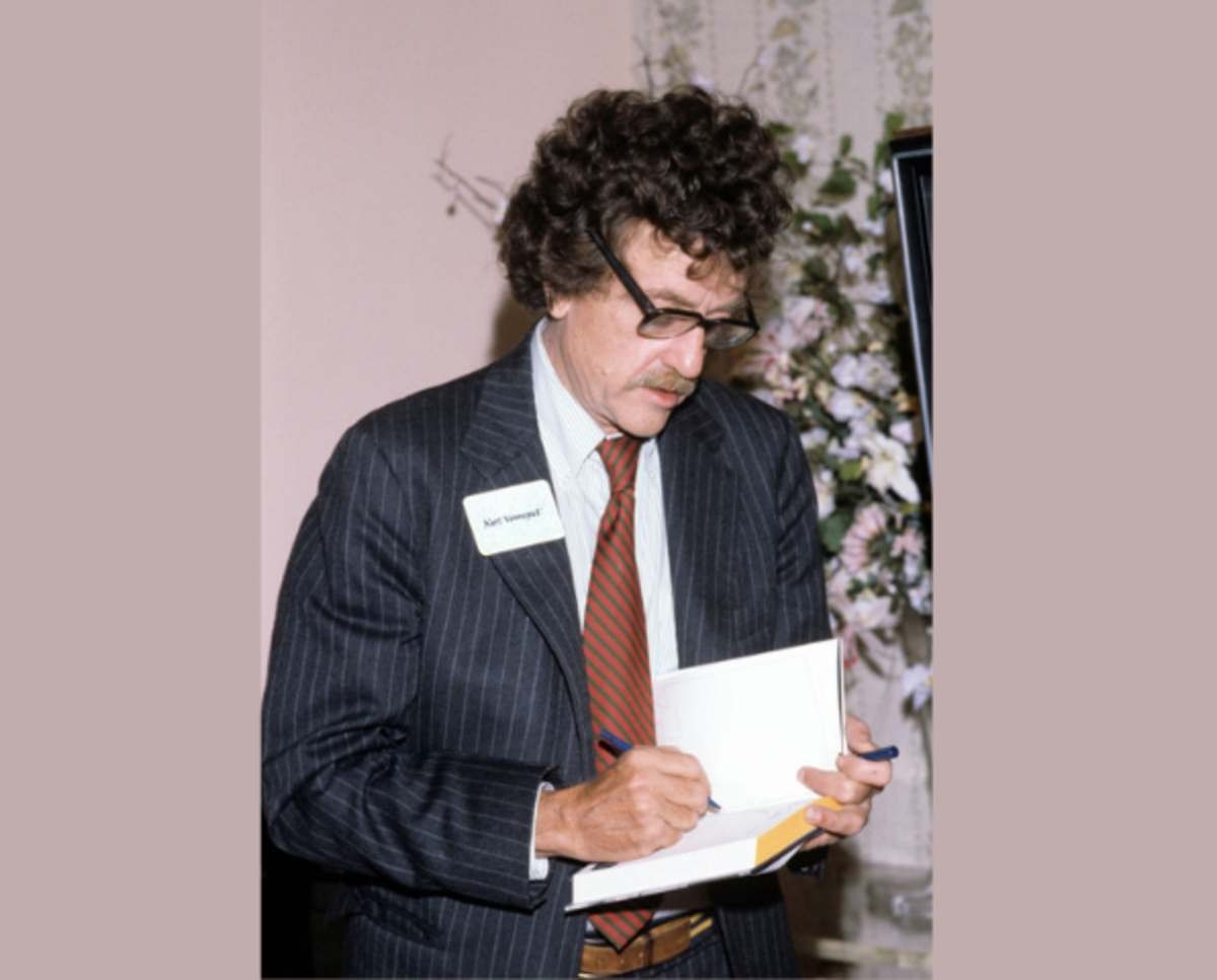 Image Source: American author Kurt Vonnegut signs a copy of his book 'Jailbird,' 1979. (Photo by Susan Wood/Getty Images)
