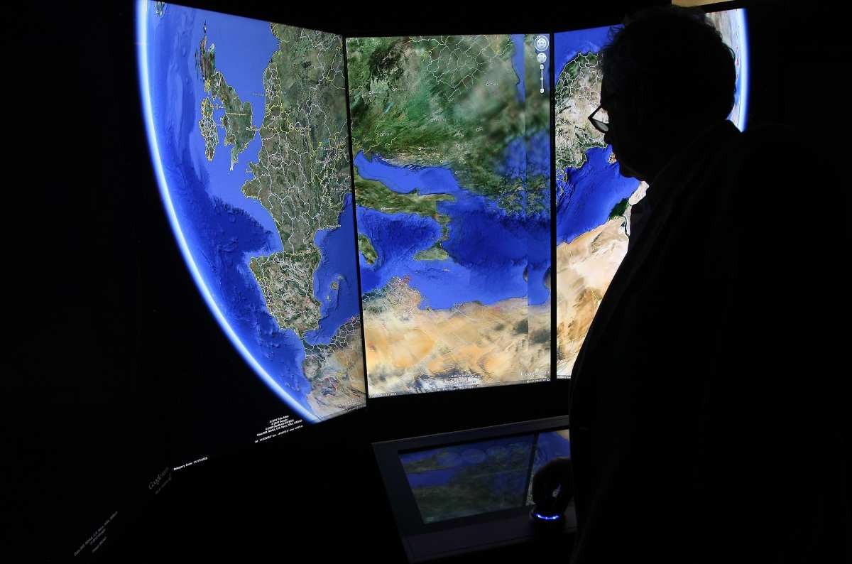 Representative Image Source: A visitor looks at a 3D rendering of planet Earth while using Google Earth at Google offices in Berlin, Germany. (Photo by Adam Berry/Getty Images)