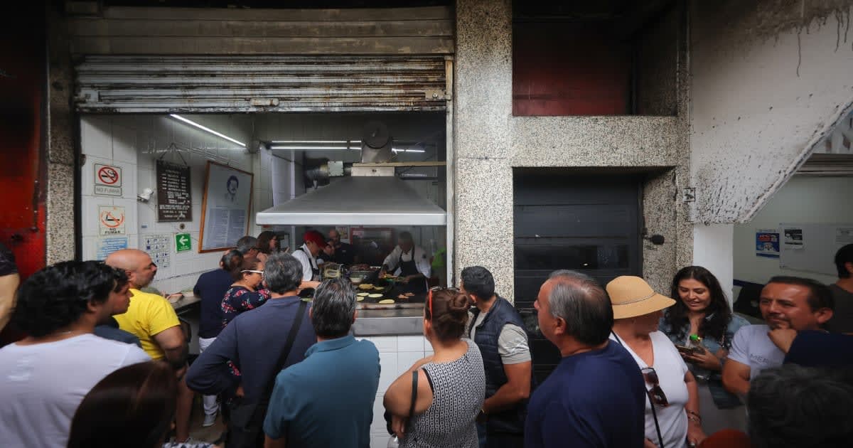 Image Source: Customers line up on the street to place their order during a visit to 'El Califa de Leon' on May 16, 2024 in Mexico City, Mexico.