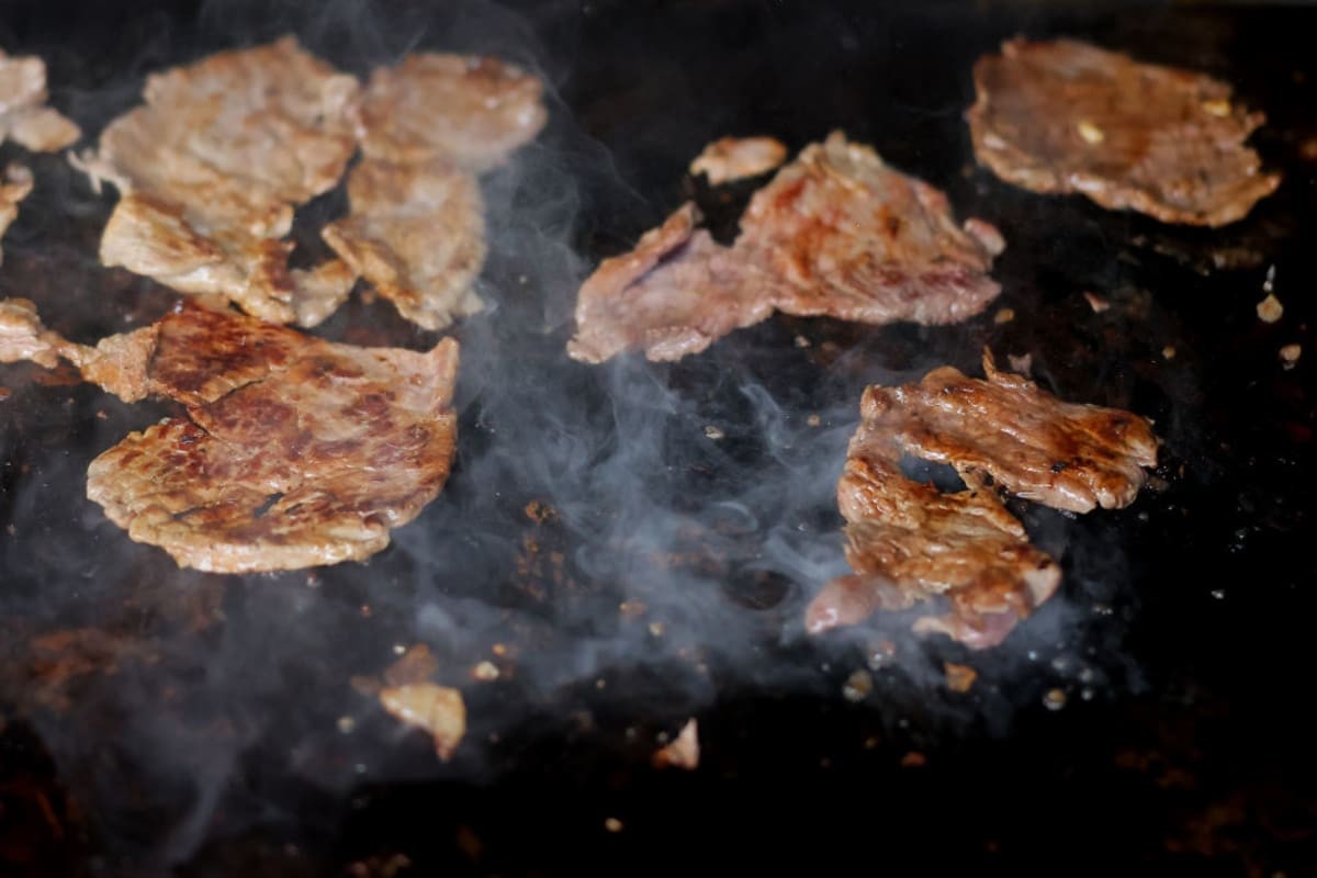 Image Source: Gaonera meat as it cooks on the grill during a visit to 'El Califa de Leon' on May 16, 2024, in Mexico City, Mexico. It became the first Mexican 'Taqueria' awarded by the worldwide 'Michelin Guide' (Photo by Hector Vivas/Getty Images)