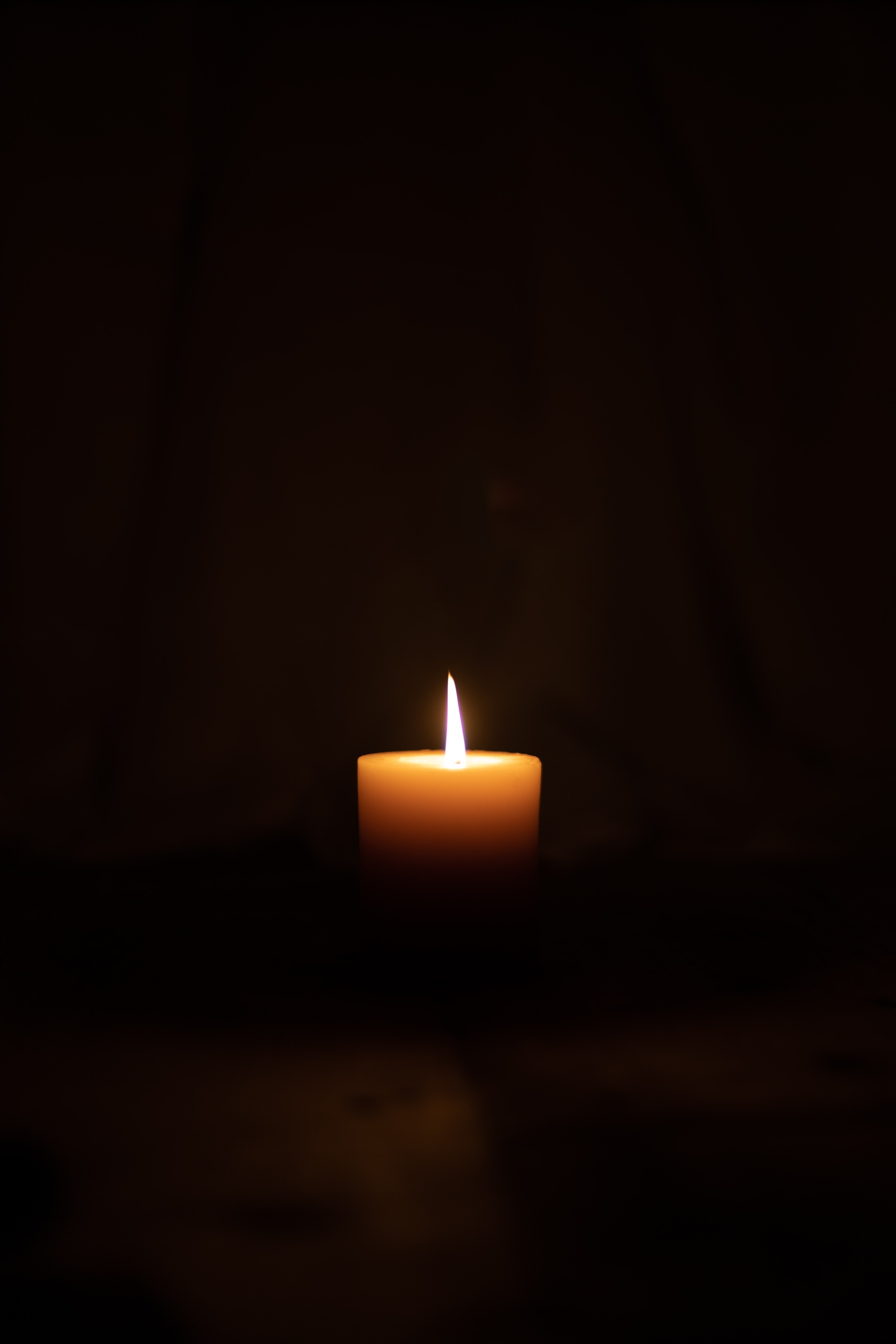 A lighted candle in dark room.