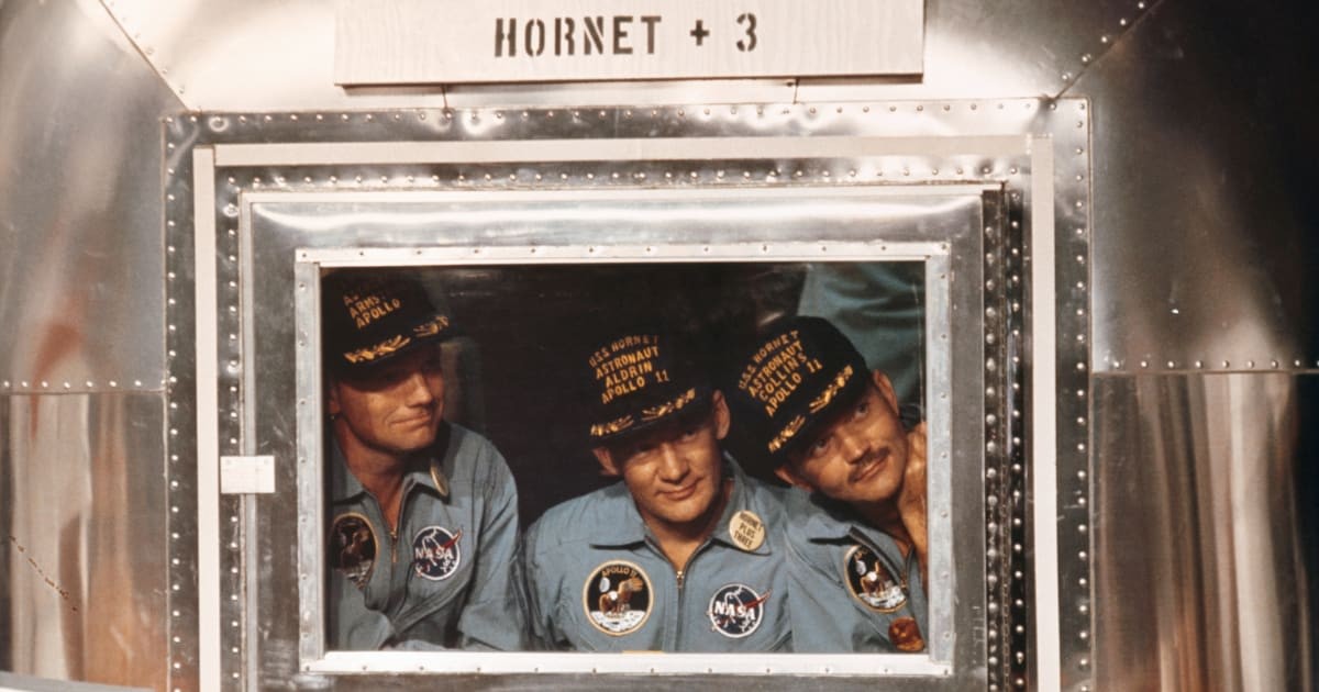 Image Source:  Wearing their baseball caps, the Apollo 11 astronauts look out from the mobile quarantine facility aboard the USS Hornet here, day after their successful splashdown in the Pacific. LTR: Neil Armstrong, Buzz Aldrin, and Michael Collins.