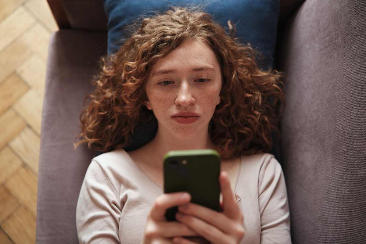 Representative Image Source: Sad lonely gen z girl lying on sofa with phone, scrolling social media, Internet addiction, wasting time. (Getty Images)