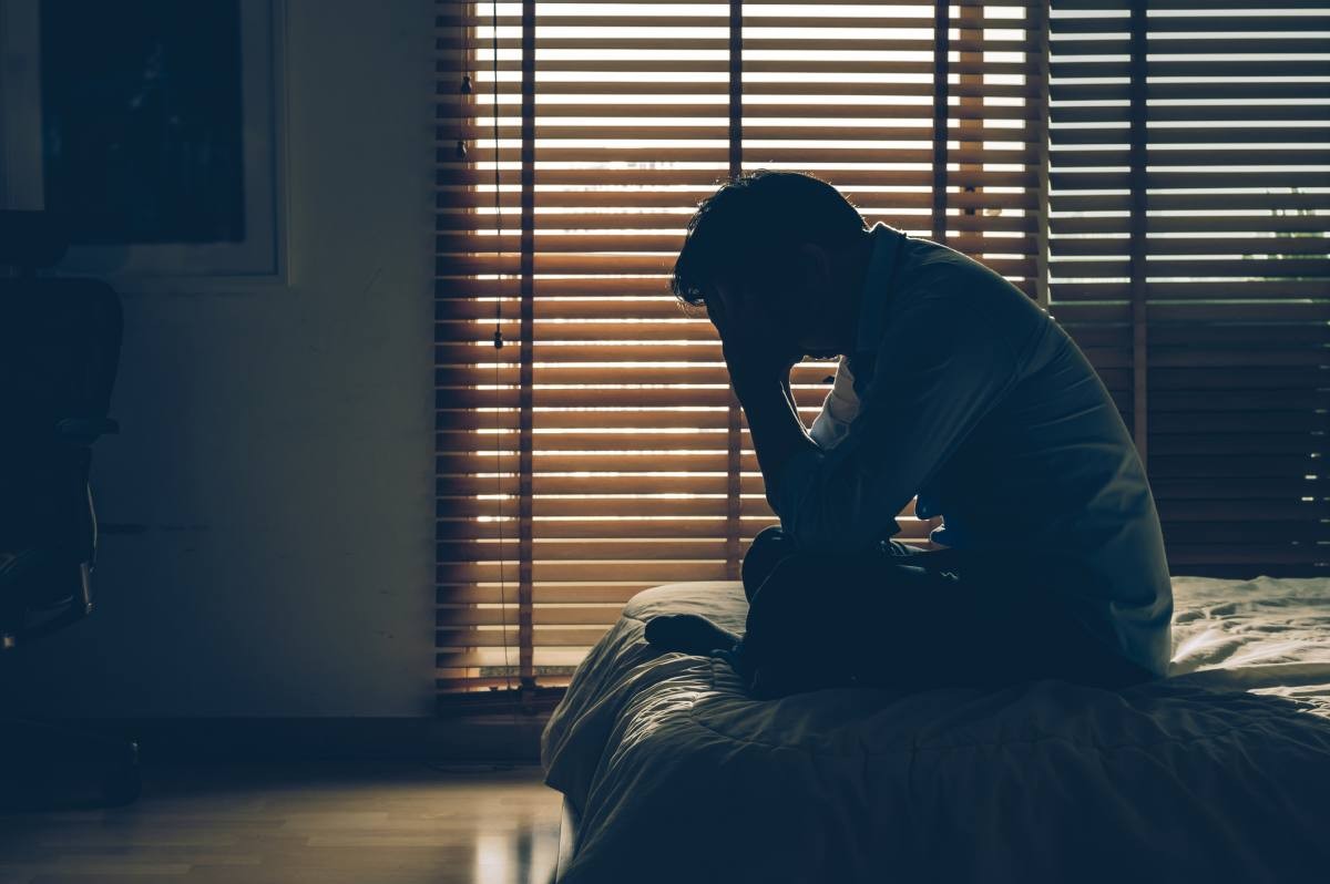 Representative Image Source: Sad businessman sitting head in hands on the bed in the dark bedroom with low light environment, dramatic concept. (Getty Images)