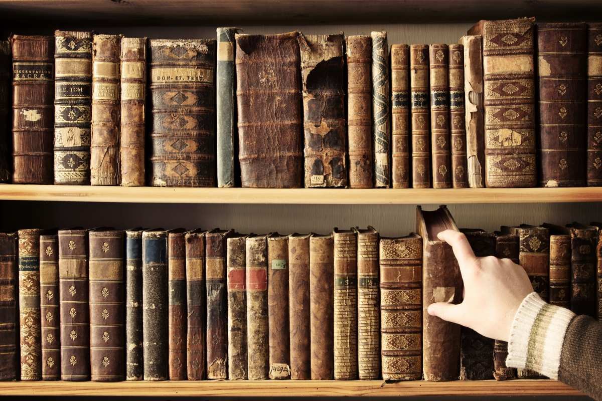 Representative Image Source: Male hand picking a book from a row of antique books. (Getty Images)