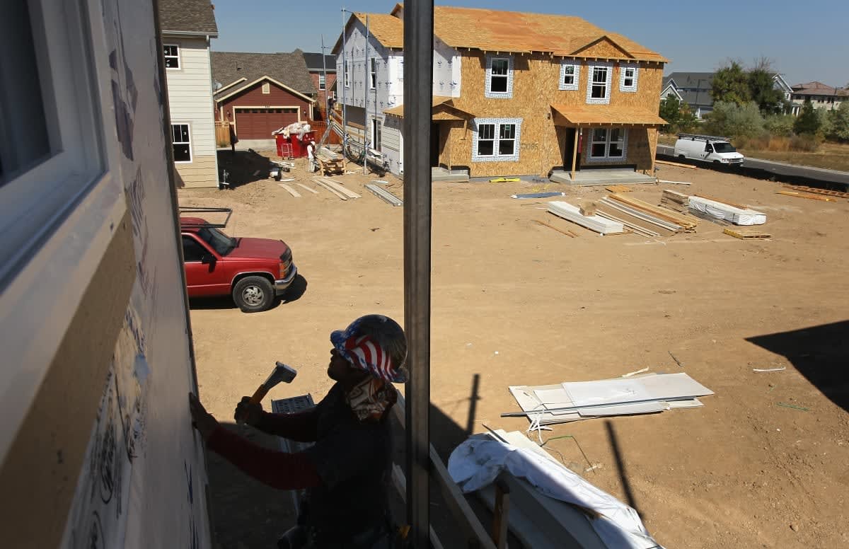 Image Source: A member of a construction crew works on the exterior of a new home in the Stapleton neighborhood of Denver, Colorado. (Photo by John Moore/Getty Images)