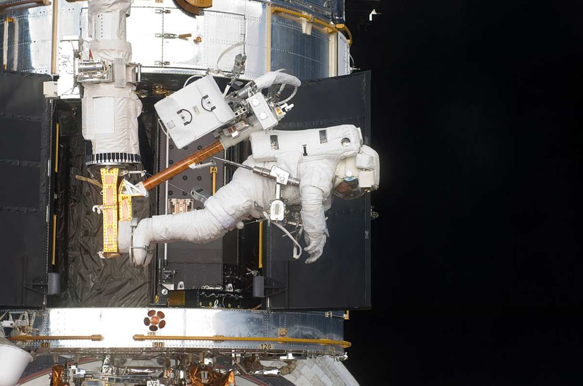 Image Source: Astronaut Andrew Feustel, STS-125 mission specialist, positioned on a foot restraint on the end of Atlantis' remote manipulator system (RMS). (Photo NASA via Getty Images)