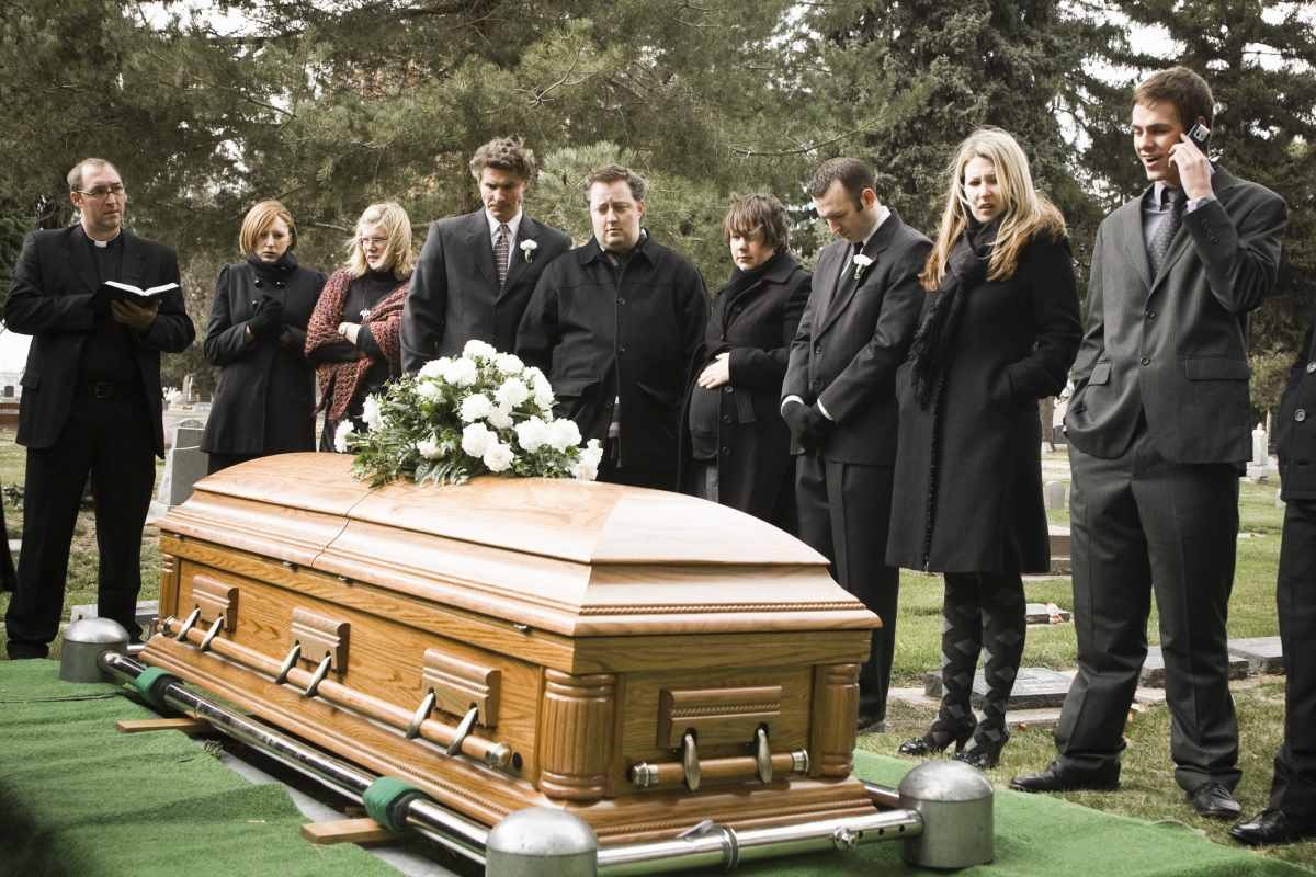 People at a funeral in a cemetery (Representative Image Source: Getty Images | Rubber Ball Production)