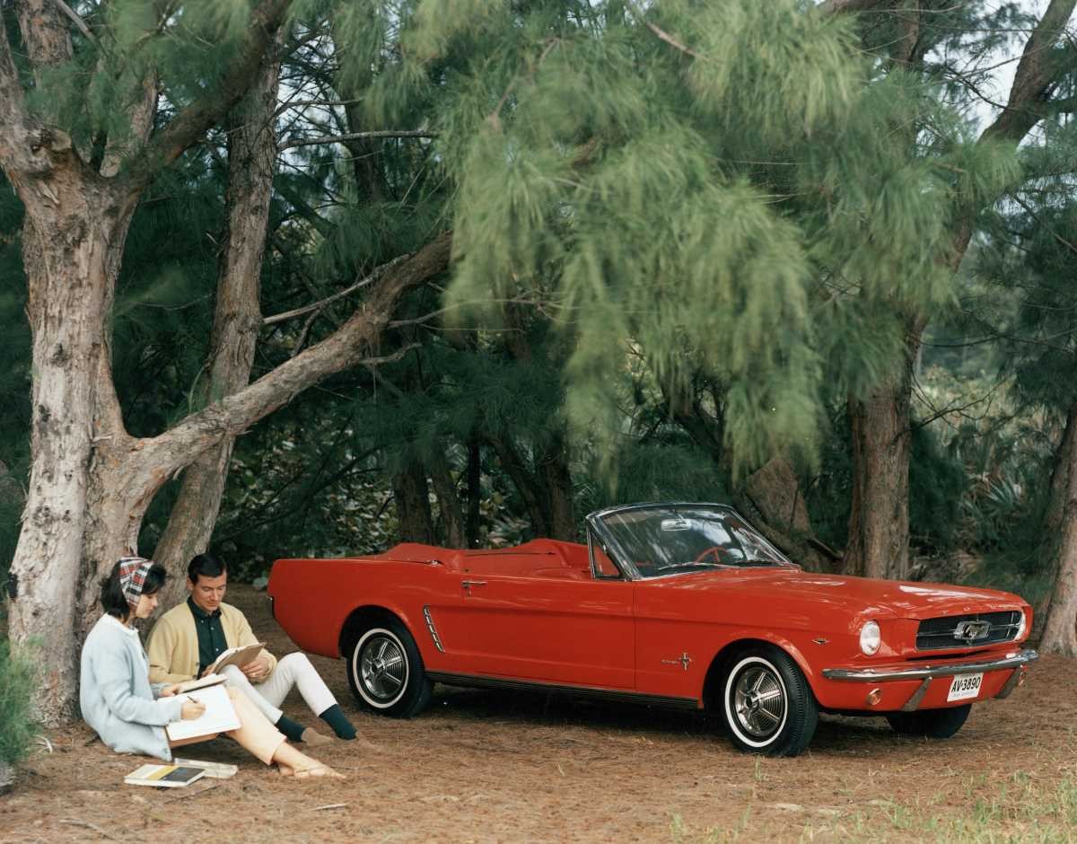 Representative Image Source: Promotional shot of a red 1964 Ford Mustang convertible parked in a forest clearing with a couple sitting by a pinetree, 1964. (Photo by FPG/Getty Images)