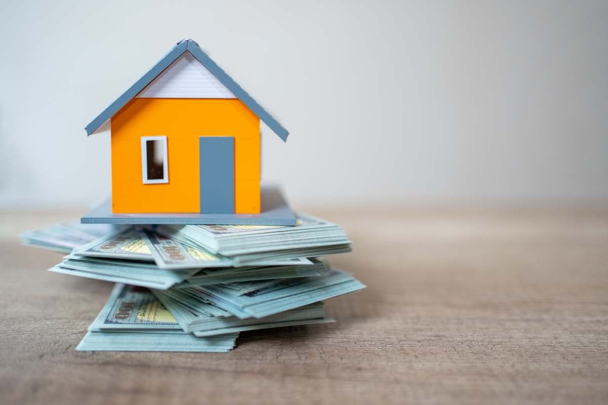 Representative Image Source: Model home on top of US paper currency. Home investment. (Getty Images)