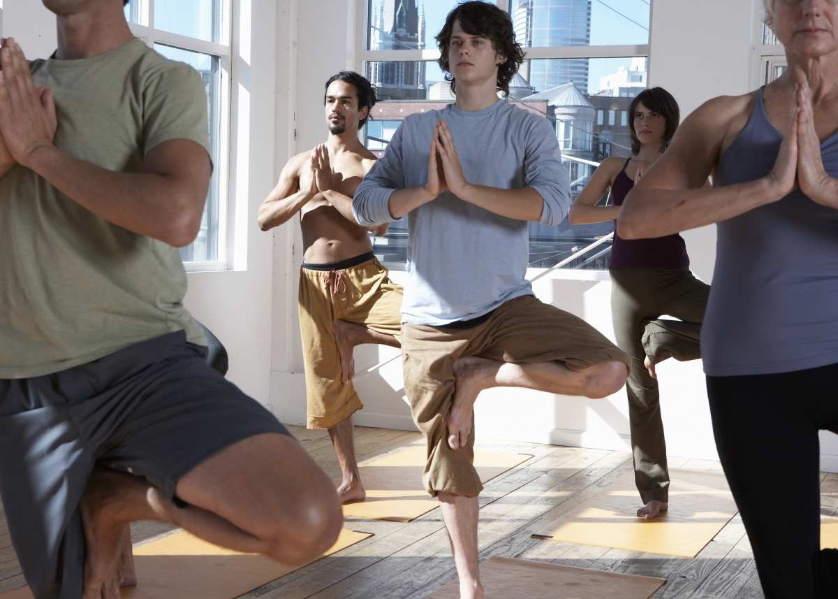 Five adults practicing yoga, standing on one leg (Representative Image Source: Getty Images | Thomas Northcut)