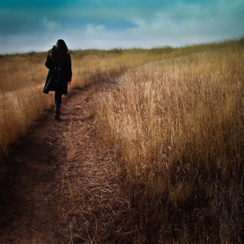 Girl walking alone in a field