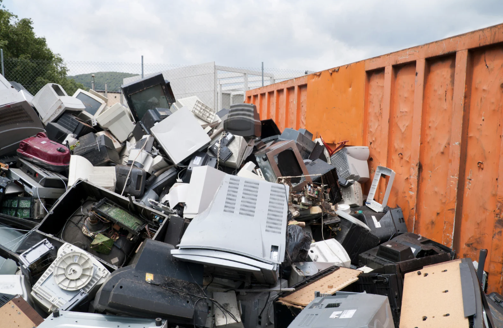 A pile of broken computers in a landfill.