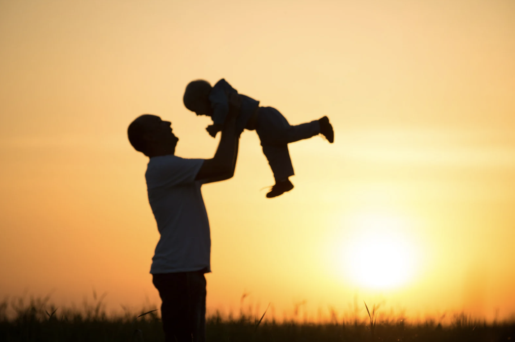 Silhouette of older man with young child
