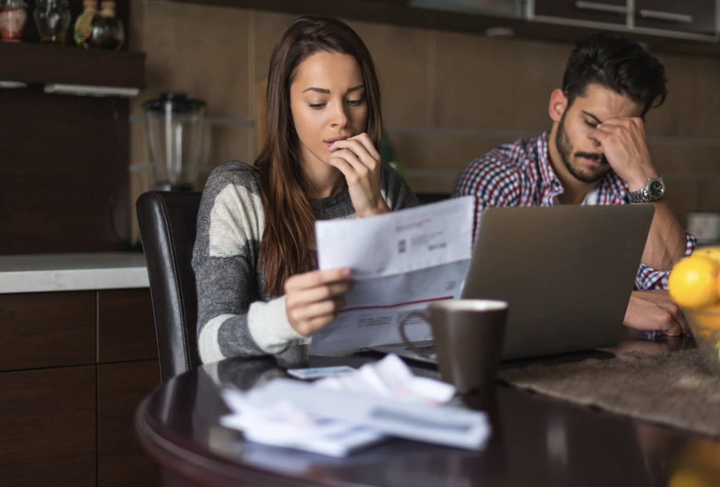 Man and woman looking worriedly at a bill.