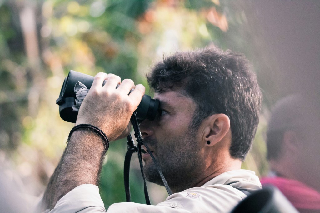 A man looks through binoculars