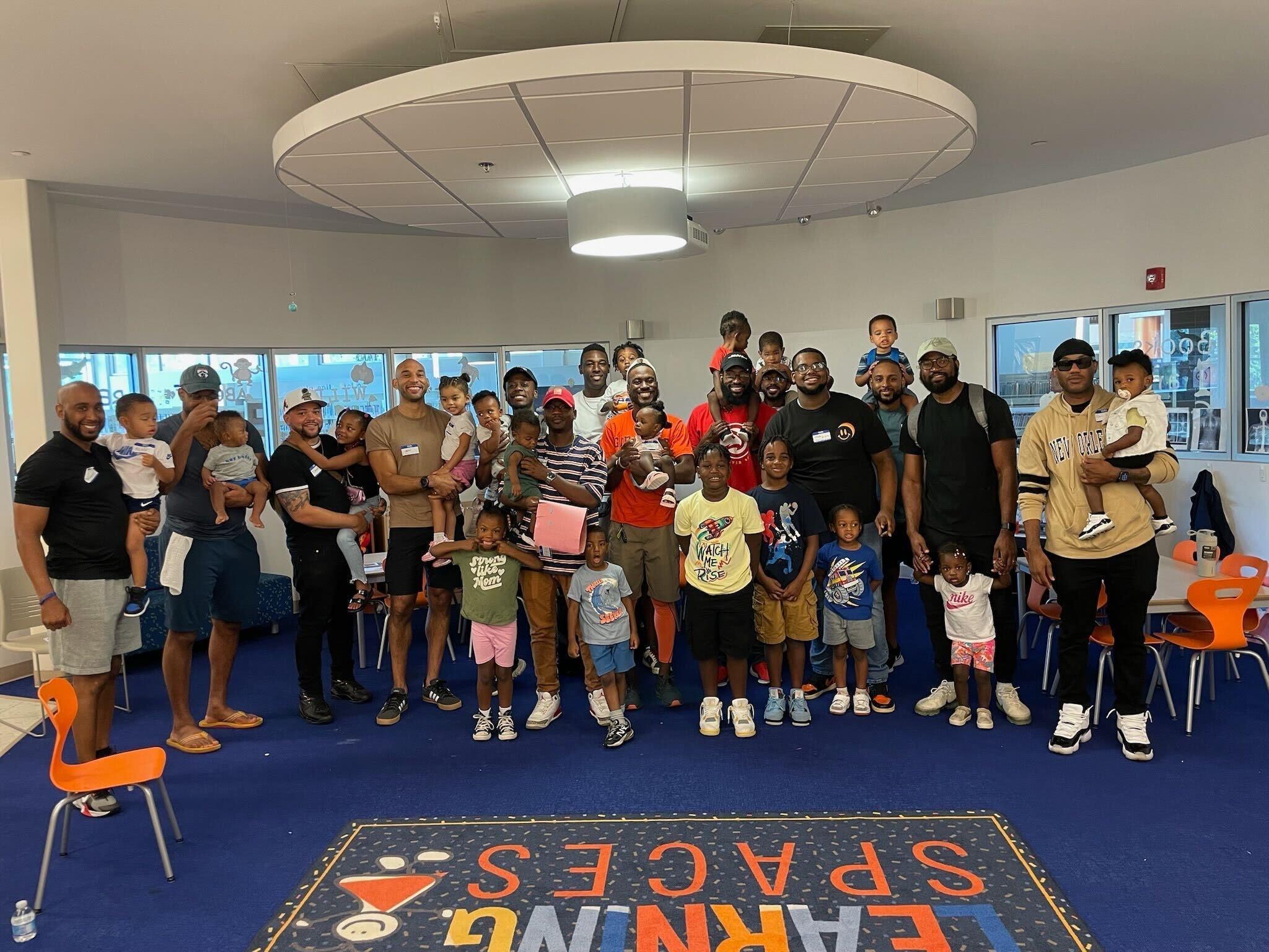 The Library Dads pose for a picture with their children.
