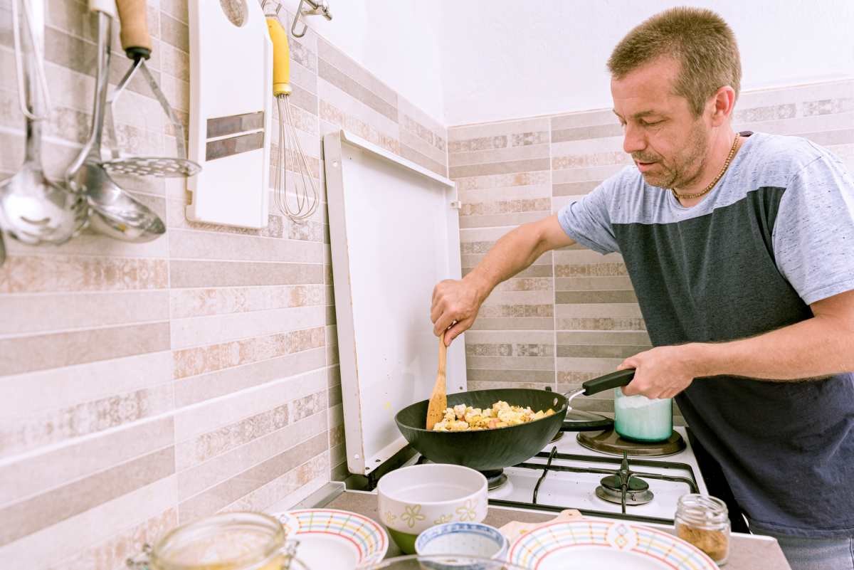 Man at Home in the Kitchen Preparing Vegetables in the Frying Pan (Representative Image Source: Getty Images | HMVart)