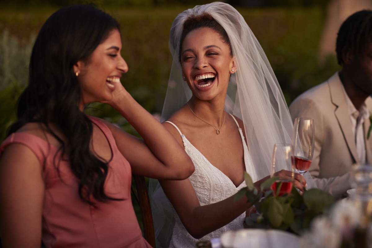 Cheerful bride and bridesmaid at dinner party (Representative Image Source: Getty Images | Klaus Vedfelt)