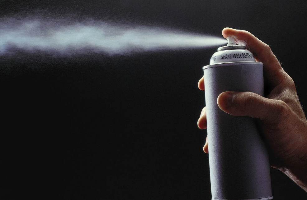 close up of a an aerosol spray can spraying