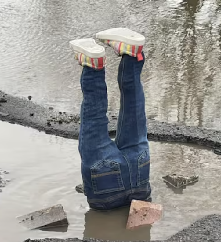 Feet sticking out of a pothole