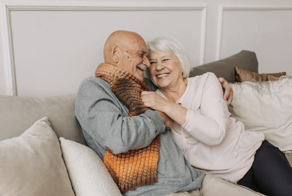 Old couple on a couch, cuddling