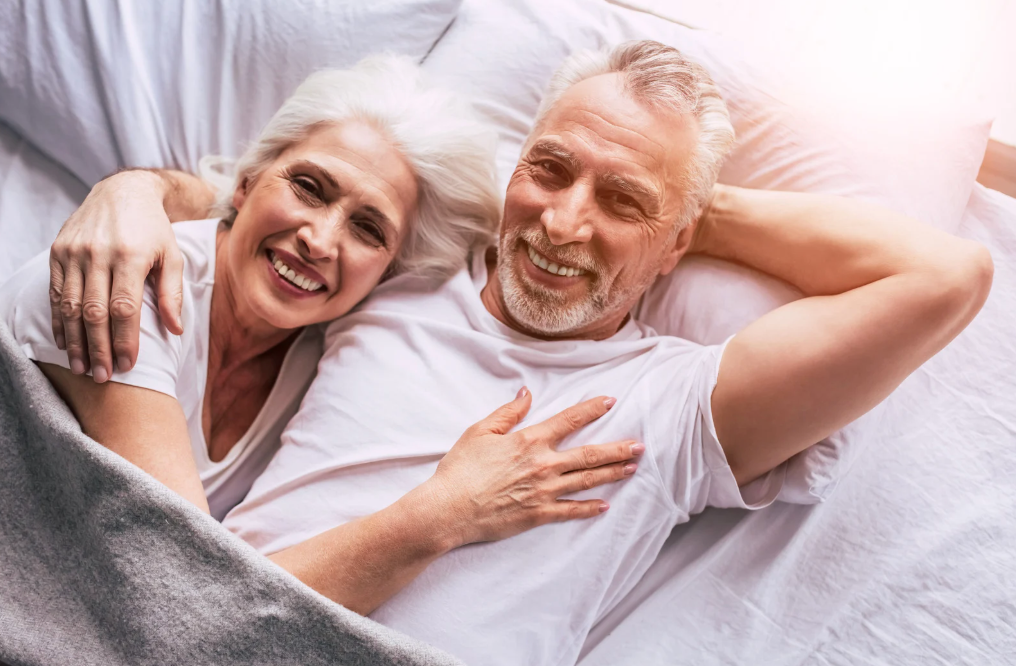 Old couple smiling in bed