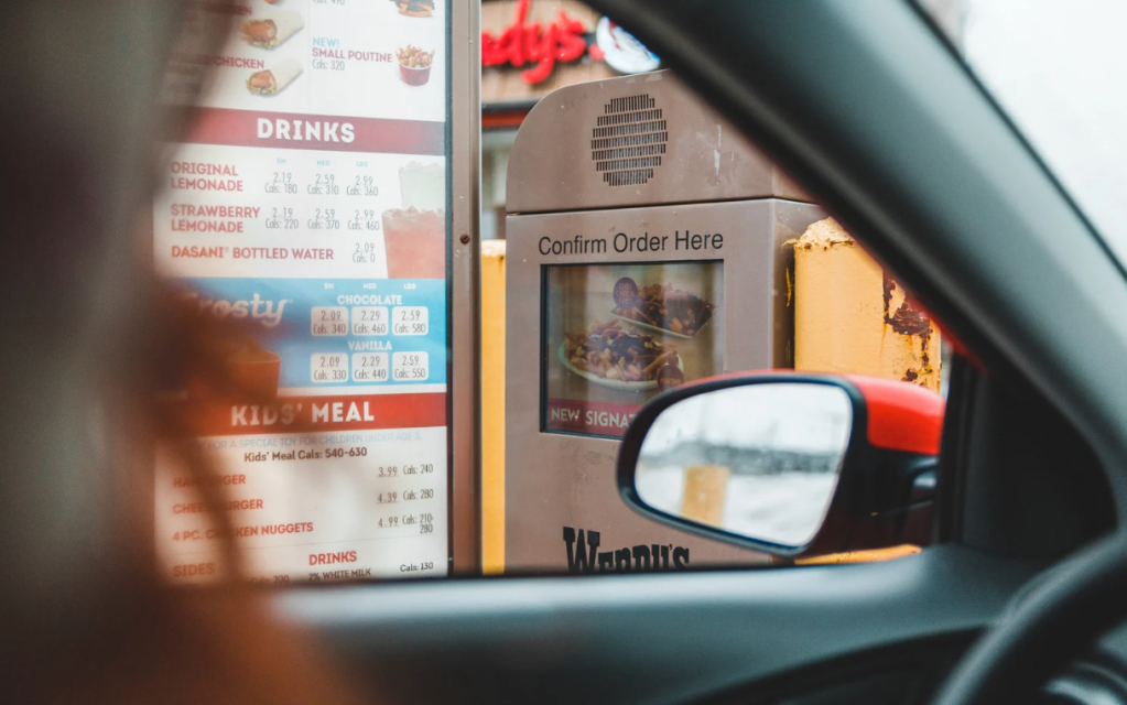 A woman at a drive-thru restaurant. 
