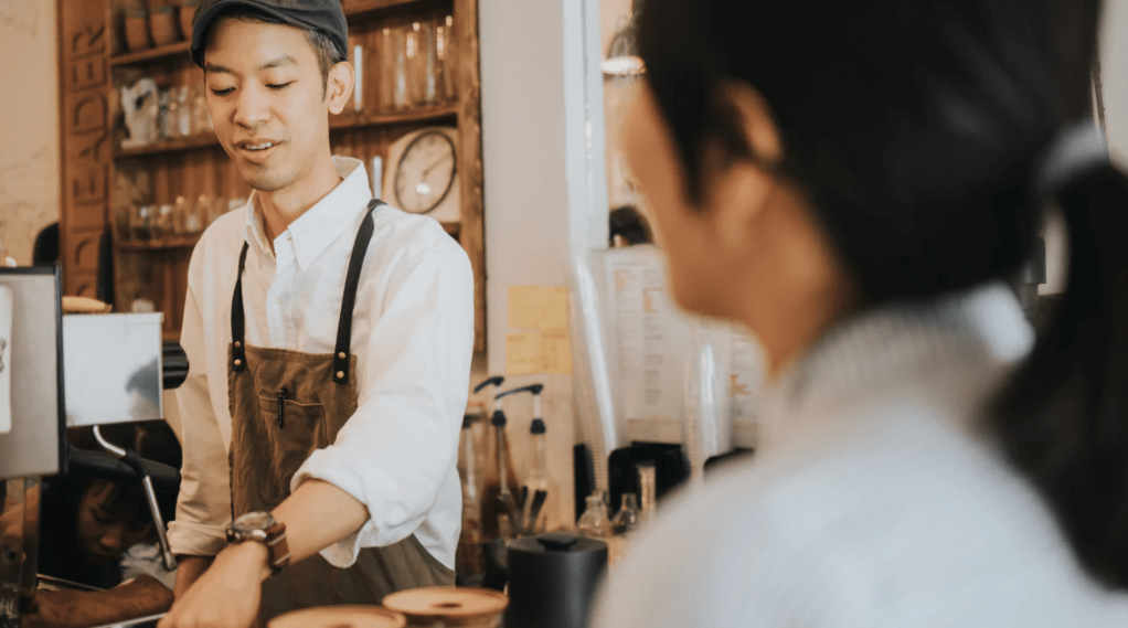 A barista serves a customer in a coffee shop