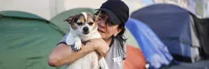 A homeless woman in Los Angeles holds her dog after a free veterinary visit in 2024.