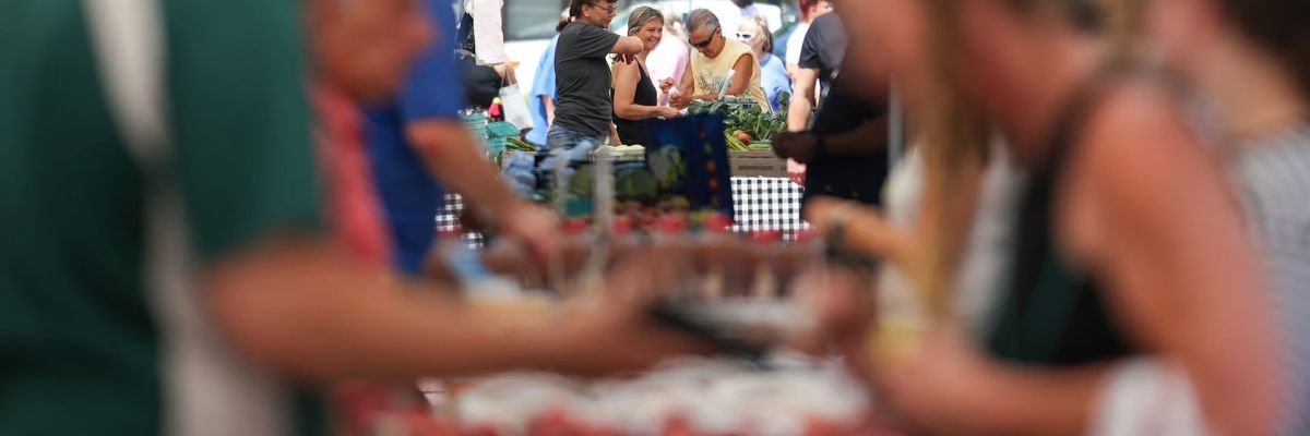 Customers browse the fresh produce at a Wilkes-Barre, Pa., farmers market in June 2025.