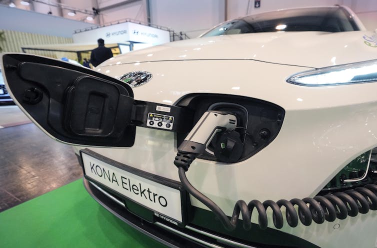 A while Hyundai Kona electric car is charged at a motor show in Essen, Germany, on Dec. 2, 2021.