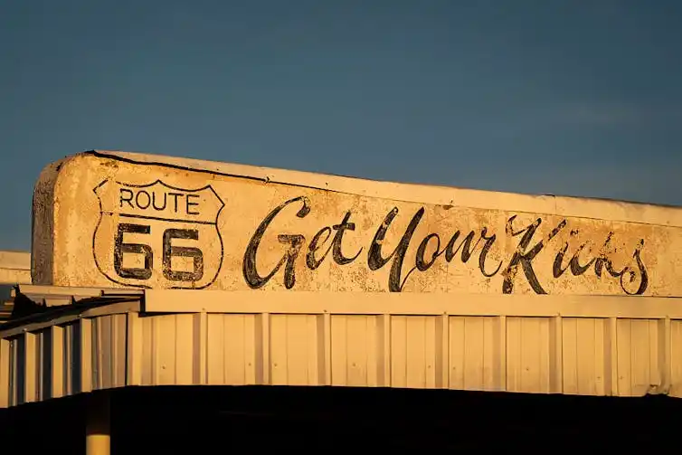 Faded sign featuring a Route 66 highway logo and the text 'Get Your Kicks.'