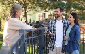 A young couple talking to a friendly elderly neighbor.