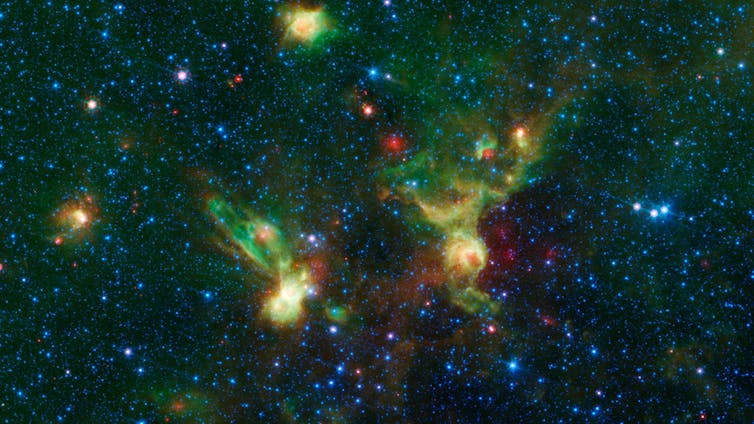 A photo of space, with some bright spots representing nebulae, including a bright spot that looks like the disc-shaped hull of the starship Enterprise from Star Trek